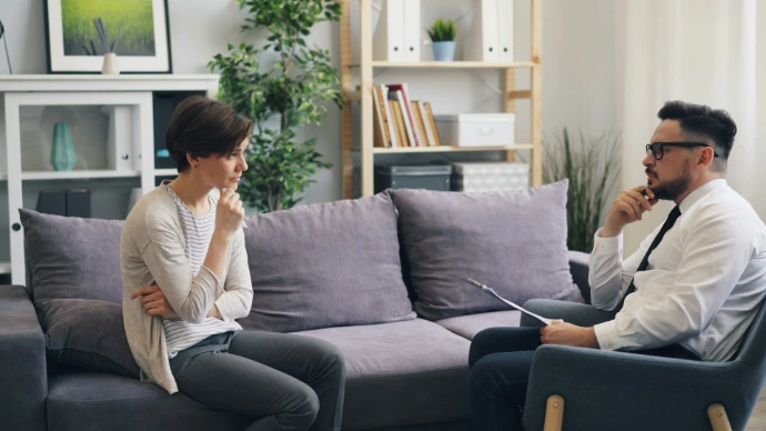a man and a woman sitting on a couch talking